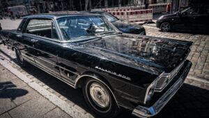 Vintage black Ford Galaxie 500 parked on a Hamburg street showcasing classic car design.